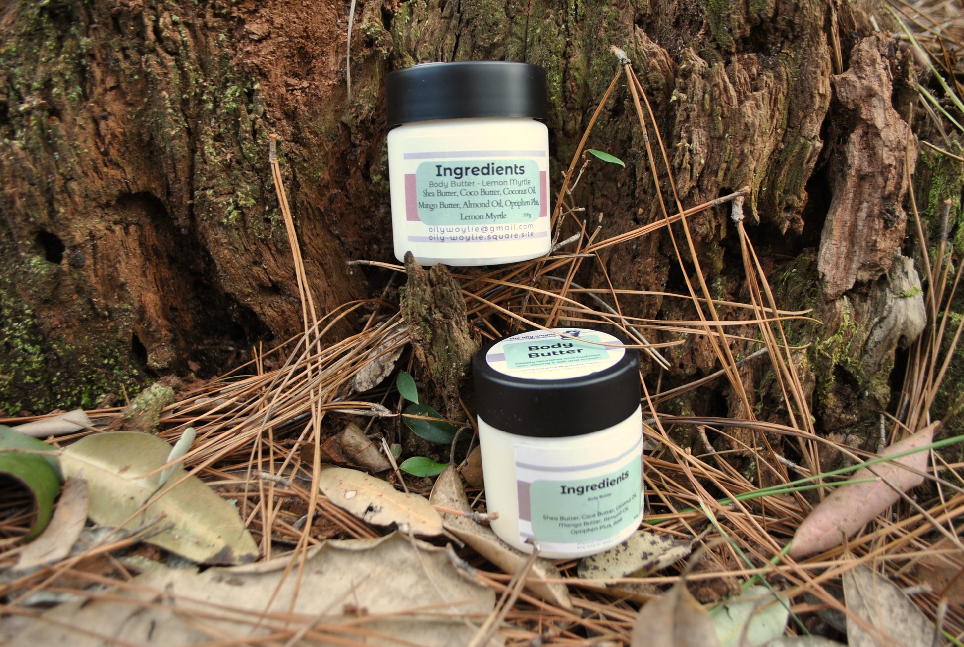 Rose and Lemon Myrtle Body Butter jars side by side, natural moisturising body creams on a natural background with leaves and wood.