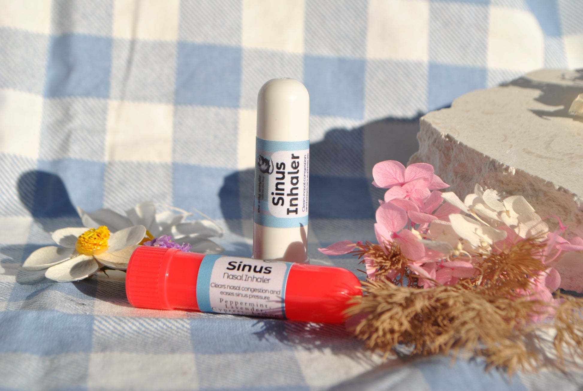 Sinus Inhaler tube, natural essential oil inhaler for sinus relief on a blue and white checkered tablecloth with flowers.