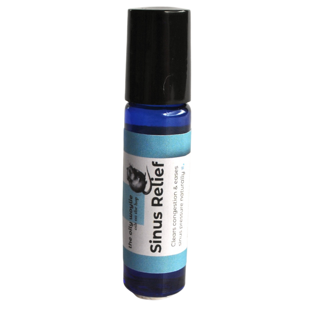 Roll-on bottle labeled 'Sinus Relief' on a white background. Sinus relief essential oil roll-on applied to temples and chest. Aromatherapy roll-on for sinus discomfort and breathing support.