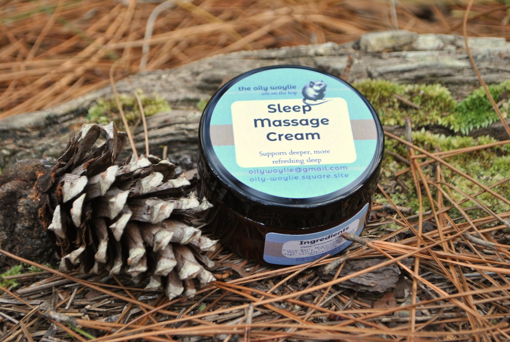 Sleep Massage Cream jar, natural cream with essential oils to support relaxation and sleep on a wooden log with pine needles