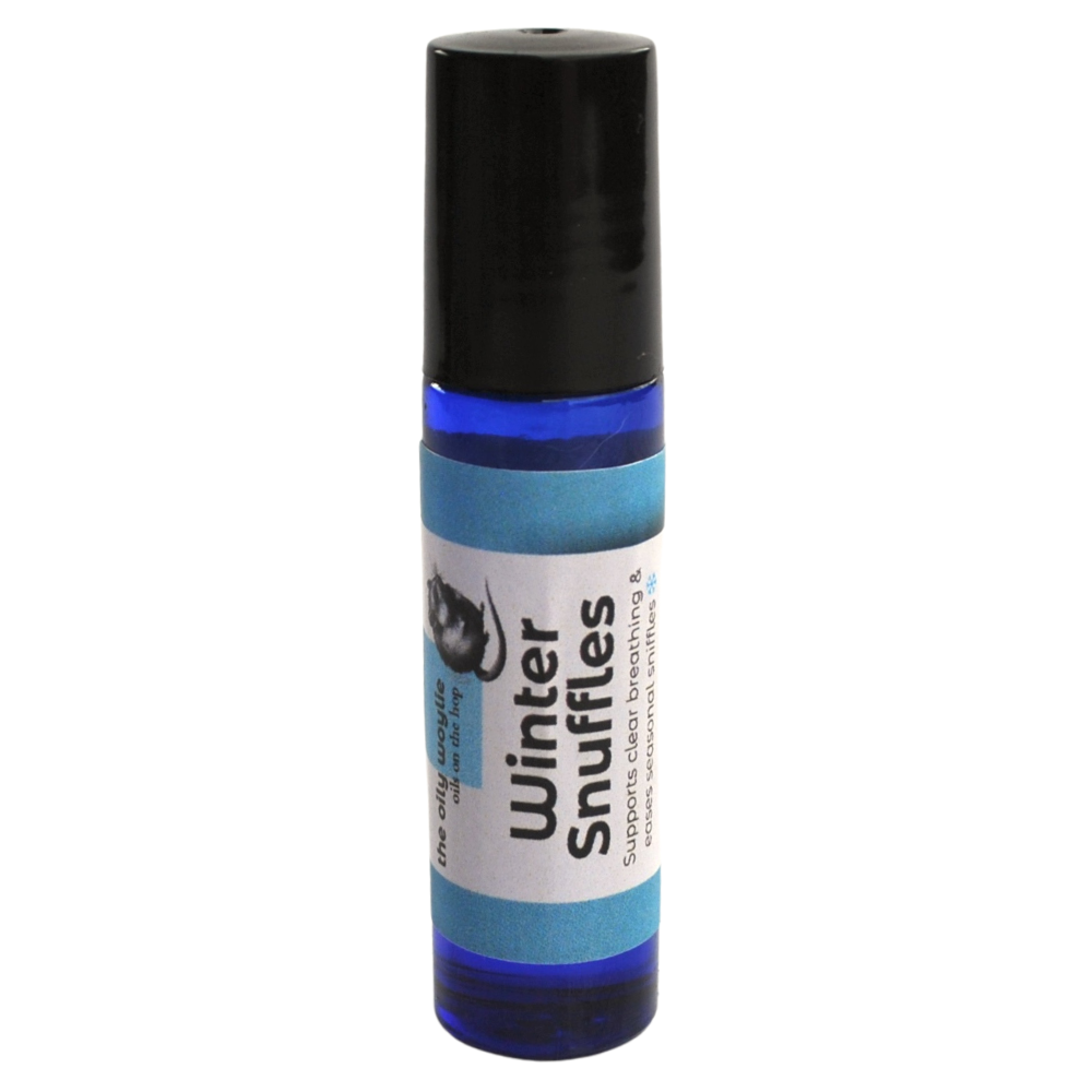 Roll-on bottle labeled 'Winter Snuffles' on a white background. Winter roll-on blend applied to chest and neck for easier breathing. Essential oil roll-on designed to comfort sniffles and support clear airways.