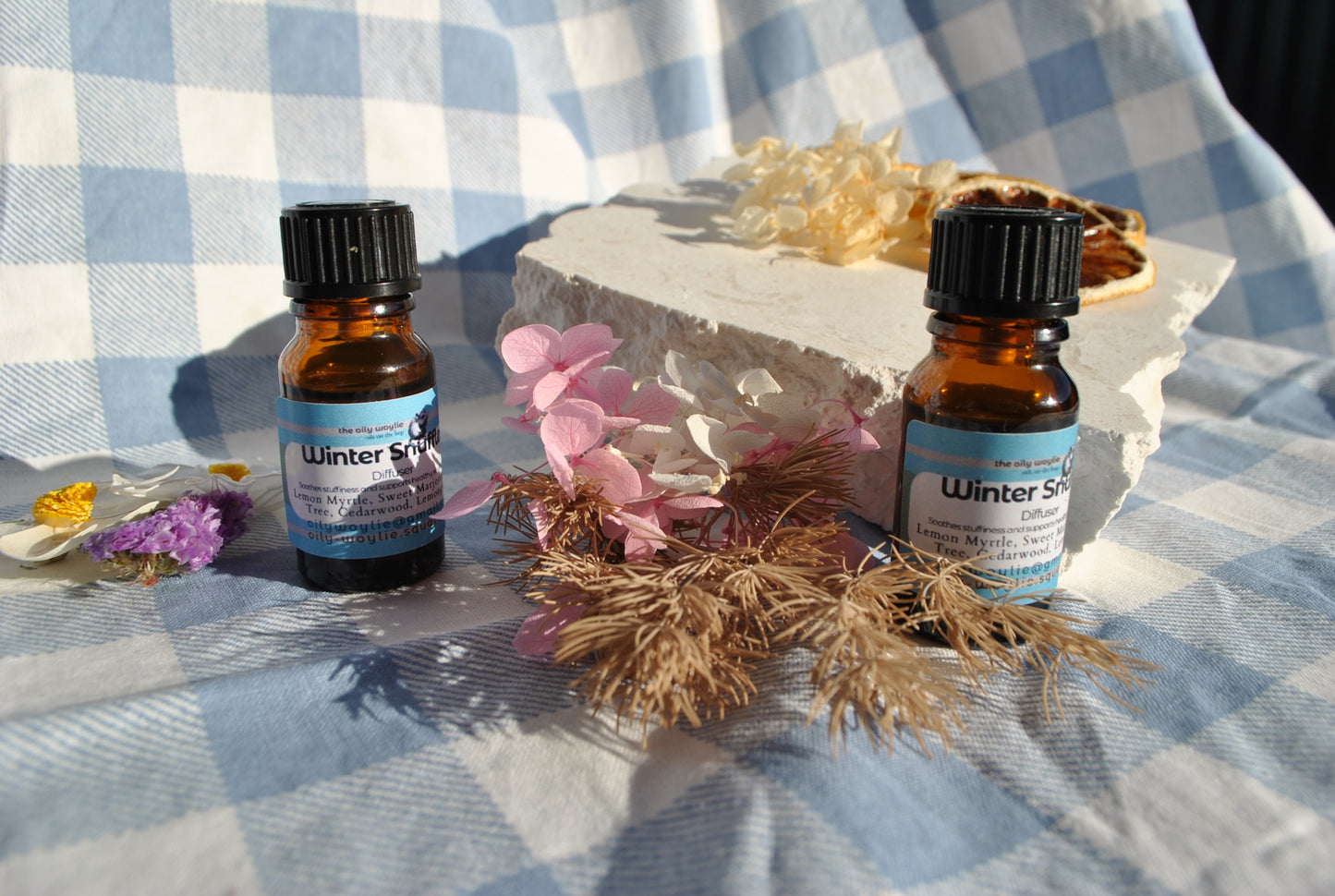 Winter Snuffles Diffuser Blend essential oil bottle, natural support for colds and congestion on a checkered background