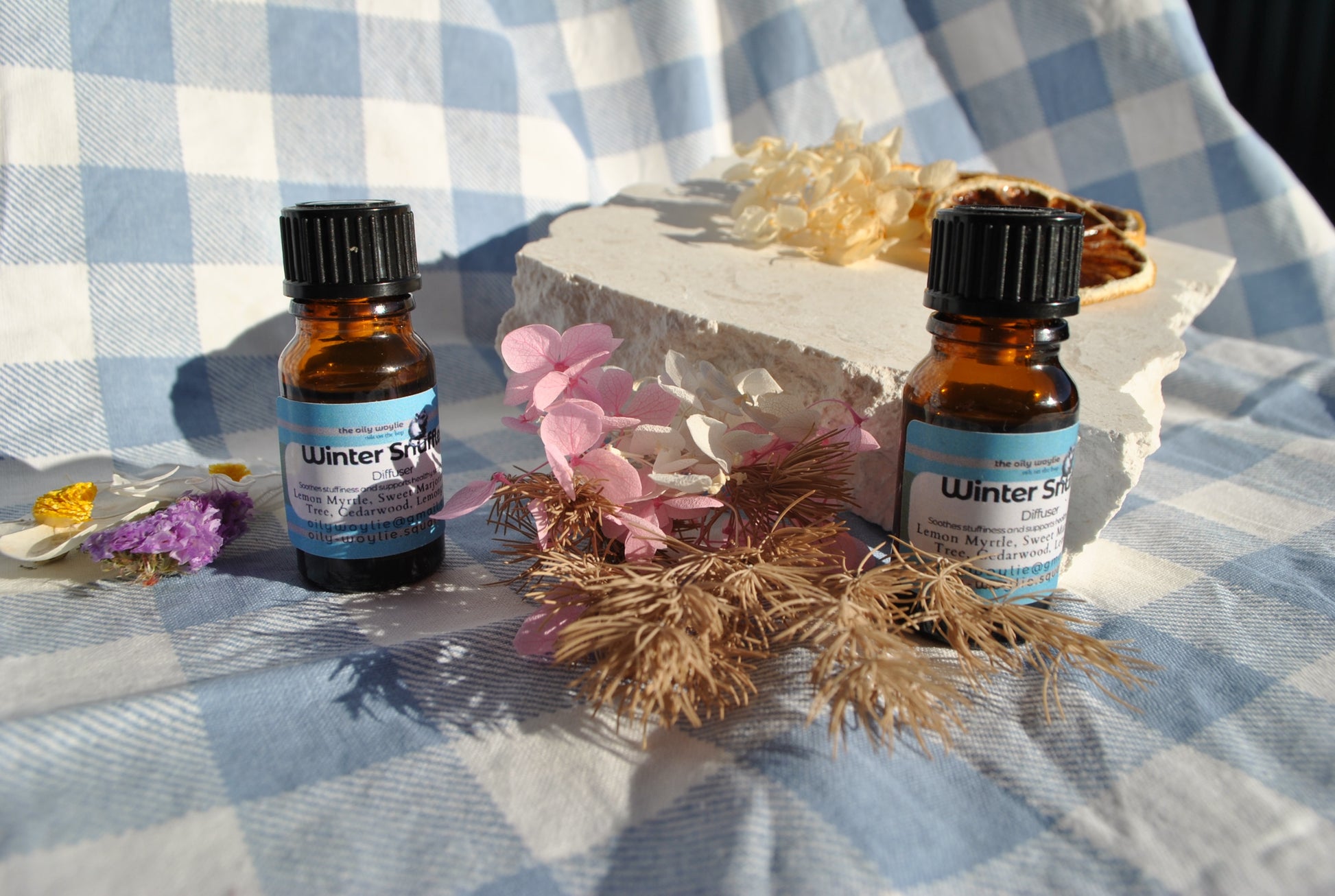 Winter Snuffles Diffuser Blend essential oil bottle, natural support for colds and congestion on a checkered background