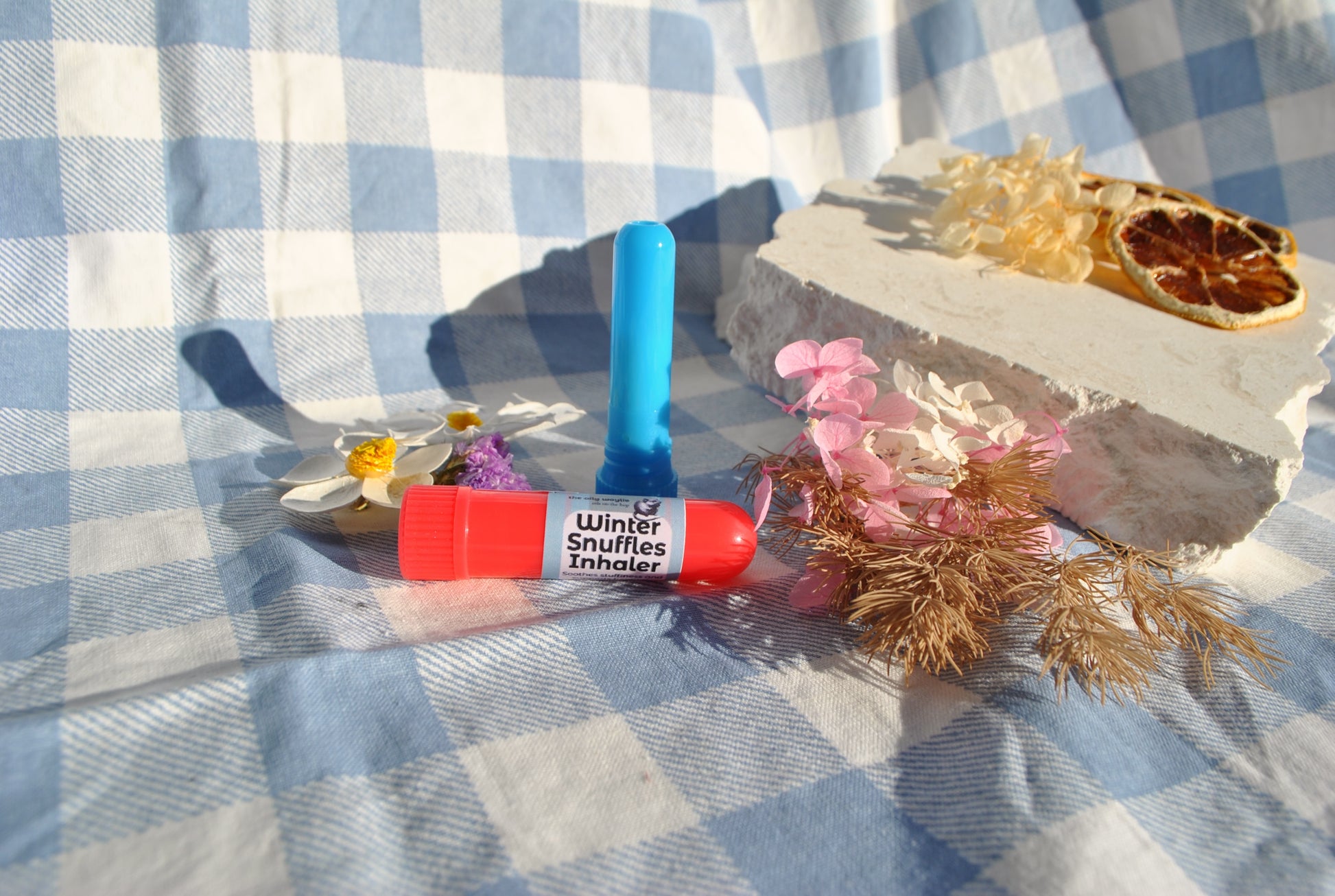 Winter Snuffles Inhaler tube, natural essential oil inhaler for colds and congestion on a checkered fabric background