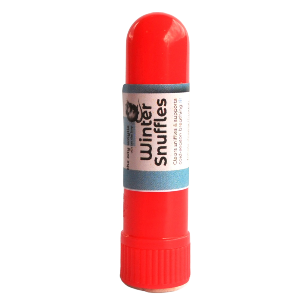 Red tube of 'Winter Snuffles' on a white background. Portable winter nasal inhaler for congestion relief on the go. Small inhaler stick used to support breathing during colds.