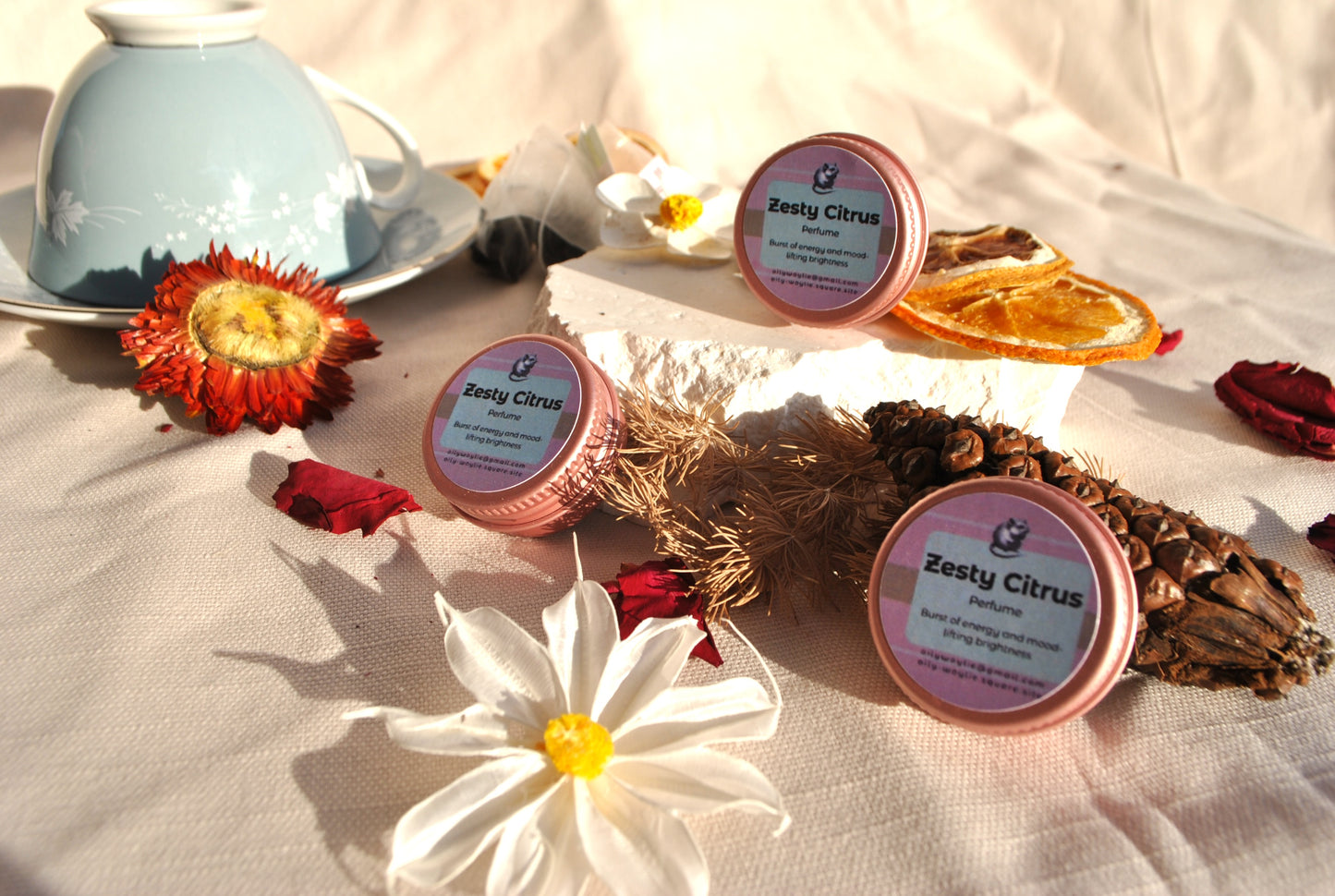 Zesty Citrus Perfume, natural refreshing fragrance with citrus scent on a decorative surface with flowers and a teacup.