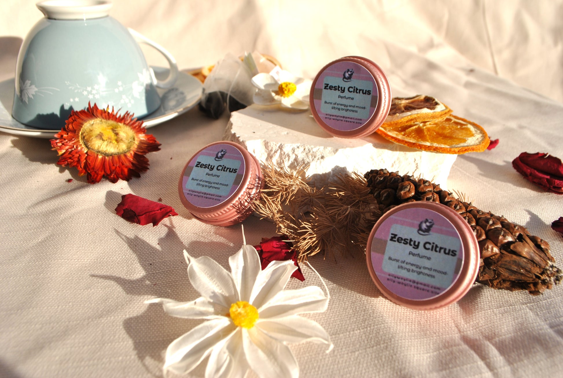 Zesty Citrus Perfume, natural refreshing fragrance with citrus scent on a decorative surface with flowers and a teacup.