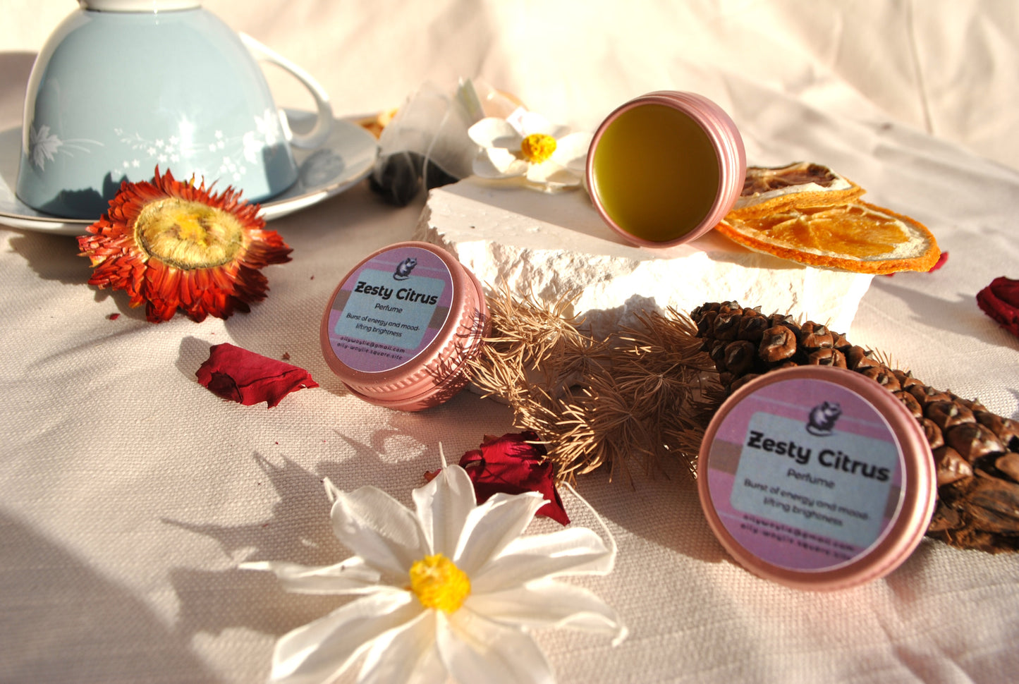 Zesty Citrus Perfume, natural refreshing fragrance with citrus scent on a table with flowers and a teacup.