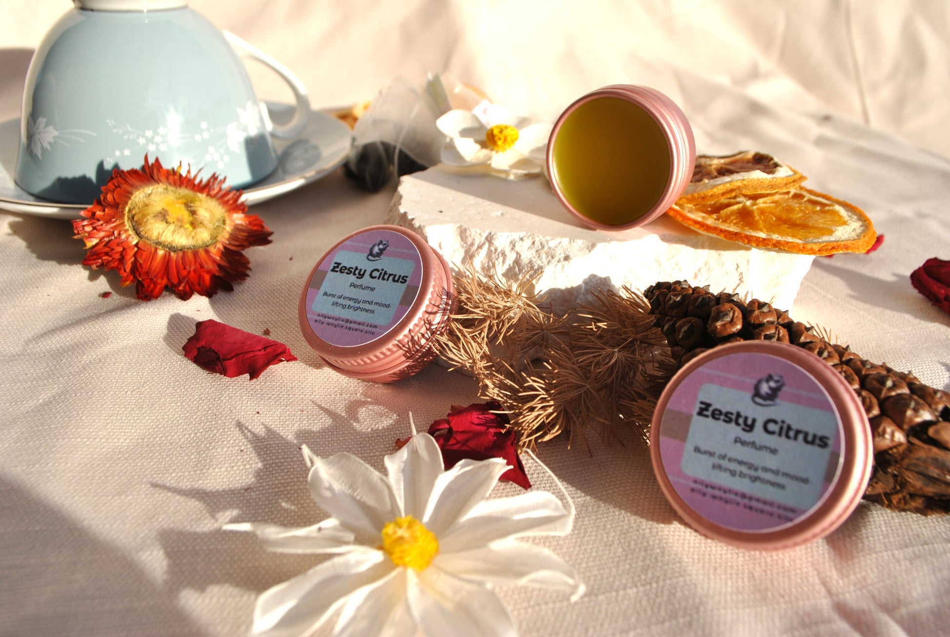 Zesty Citrus Perfume, natural refreshing fragrance with citrus scent on a table with flowers and a teacup.